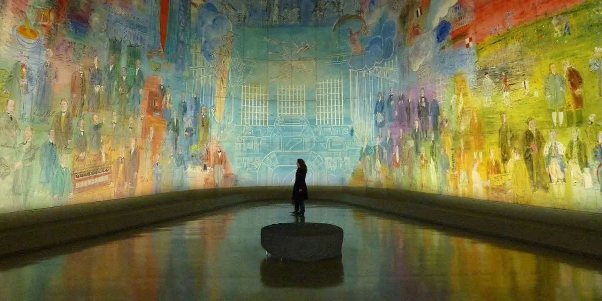 Woman looking at a picture in a dark room in a museum Woman looking at a picture in a dark room in a museum